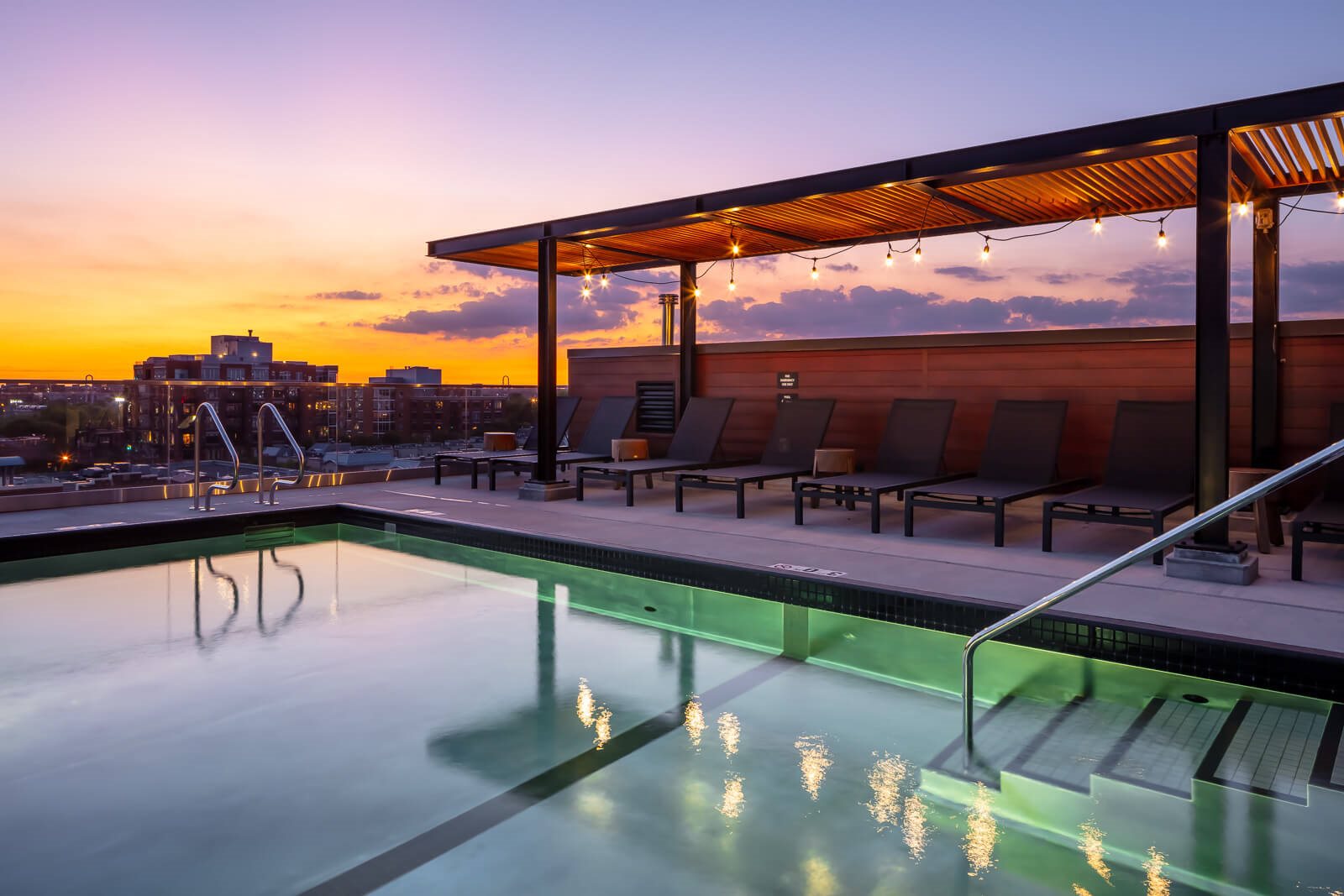 Pool on rooftop with lounge seating under pergola